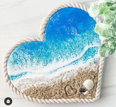 a heart shaped cookie sitting on top of a table next to a potted plant