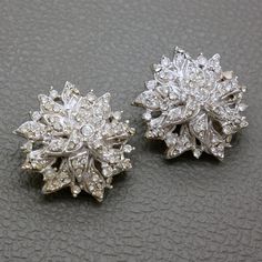 These exquisite vintage ST. JOHN clip-on earrings from the 1980s are a statement piece that beautifully combines elegance and glamour. Crafted in a luxurious white gold looks metal and adorned with sparkling rhinestone crystals, these earrings feature an intricate flower design that is perfect for special occasions such as weddings, bridal events, or formal gatherings. The large, bold floral design offers a dazzling appearance that resembles diamonds, making them the ideal accessory to elevate a Bridal Events, Earrings White Gold, Bridal Event, Earrings White, Gold Rhinestone, Crystal Flower, 1980s Vintage, Vintage Costume Jewelry, Antique Items