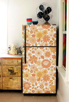 an old refrigerator is covered in floral fabric