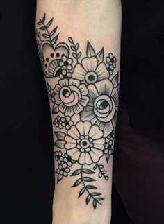 a black and white flower tattoo on the right arm with an eyeball in it