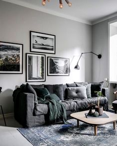 a living room filled with furniture and pictures hanging on the wall above it's coffee table