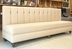 a white couch sitting in a room next to a wooden shelf