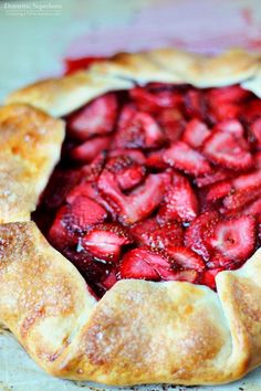 a pie with strawberries in it sitting on top of a table