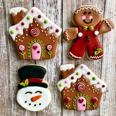 four decorated gingerbread cookies sitting on top of a wooden table