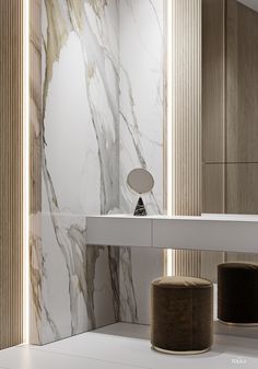 a bathroom with marble walls and white counter tops, along with two stools in the foreground