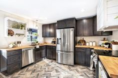 a kitchen with wooden counter tops and stainless steel refrigerator freezer, dishwasher