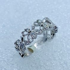 a white gold ring with diamonds on it in the middle of some snow covered ground