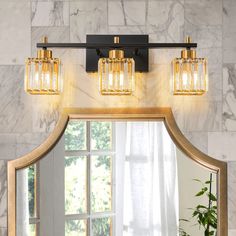 a bathroom vanity light with three lights on it and a mirror in front of it