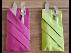 two napkins with forks on them are sitting next to each other in front of a wooden table