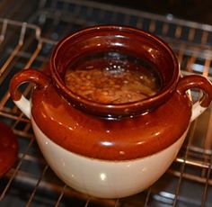 a pot filled with soup sitting on top of an oven rack