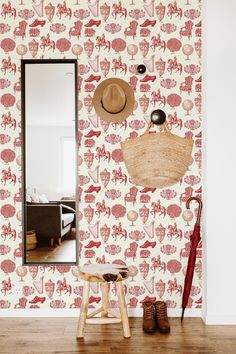 a room with a mirror, stool and wallpaper that has red animals on it