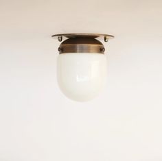 a light fixture hanging from the ceiling in a room with white walls and flooring