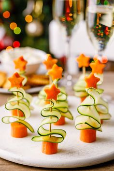 small christmas trees made out of cucumbers and carrots on a white plate