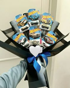 a person holding a bouquet of hot wheels