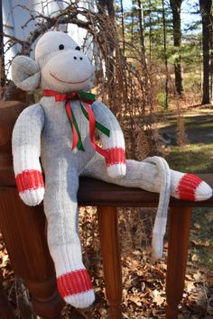 a sock monkey sitting on top of a wooden bench