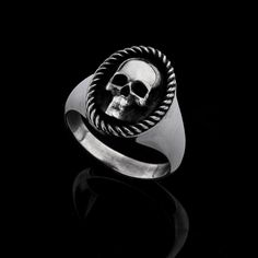 ELIZABETH- Sterling silver oval skull ring with rope decoration frame. Solid Silver ring. Silver Weight: approx. 11 gr. Top dimensions: approx. 17.3/12.3 mm This striking sterling silver skull ring is a bold statement piece perfect for those who love gothic, biker, or punk-inspired jewelry. The finely detailed skull at the center is framed by an intricately braided edge, creating a captivating contrast against the polished silver. Handcrafted from high-quality 925 sterling silver, this men's ring combines durability with edgy elegance, making it the ideal accessory for those who embrace individuality and a rebellious spirit. Whether you're looking for a unique addition to your jewelry collection or a meaningful gift for someone who loves gothic fashion, this skull ring will stand out. Perf Luxury Sterling Silver Skull Open Ring, Keith Richards Jewelry, Keith Richards Skull Ring, Sterling Silver Skull Rings, Head Skull, Jewelry Design Studio, Rope Frame, Rope Decor, Silver Skull Ring