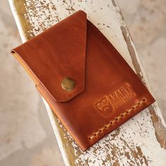 a brown leather wallet sitting on top of a wooden bench