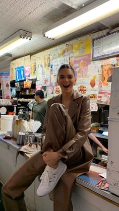 a woman is sitting on the counter at a fast food restaurant and smiling for the camera