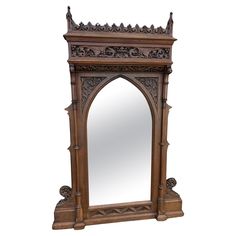 an ornate wooden mirror frame with carvings on the top and bottom, sitting against a white background