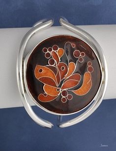 "Sterling silver cuff bracelet with circular cloisonne design for a petite wrist. Cloisonne done with silver wire and enamel. Signed \"Dewey\". Likely an American piece; appears to date to the 1960-1970's. It is not stamped sterling, but we have tested it and guarantee it to be so. Inner circumference (including gap): 7 inches. Please note that the gap is very tiny (about 1 inch), so you will need a petite wrist in order to put this on! Weight: 45.3 grams; 1.58 ounces." Sterling Silver Collectible Bangle, Unique Enamel Bracelets As Gift, Unique Nickel-free Cuff Bracelet, Unique Nickel-free Round Cuff Bracelet, Adjustable Enamel Bangle As Gift, Adjustable Enamel Bangle For Gift, Adjustable Round Enamel Bracelets, Adjustable Enamel Bangle As A Gift, Black Enamel Bracelets As Gift