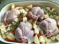 two raw chickens and potatoes in a casserole dish