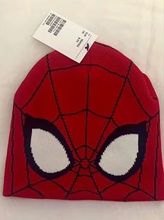 a red spiderman hat with white eyes on the front and black lines on the back