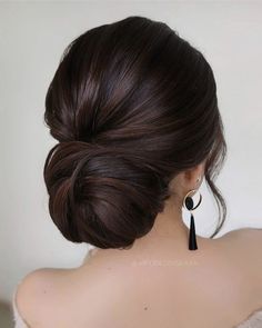 the back of a woman's head with her hair in a low bun