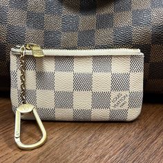 a louis vuitton purse with a keychain hanging from it's side