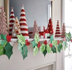 a mantel decorated with christmas trees and candy canes