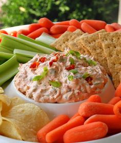 carrots, celery, crackers and dip on a plate