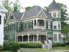 a large green house sitting on the side of a road