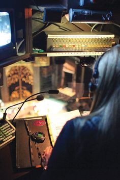 a woman sitting in front of a computer monitor next to a keyboard and mouse on a desk