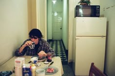 a person sitting at a table with food and drinks in front of them on the floor