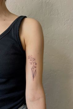 a woman's arm with a flower tattoo on the left side of her arm