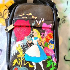 Super Cool Disney Alice In Wonderland Crossbody Bag. It Has A Large Zipper Compartment And A Smaller Zipper Compartment On The Front With An Adjustable Strap. Great For Travel Or Everyday Use. Made Out Of A Soft Leather Material. Disney Style Crossbody Shoulder Bag With Adjustable Strap, Disney School Bag With Adjustable Strap, Disney Style Crossbody Bag For Daily Use, Disney Style Backpack Bag As Gift, Disney Travel Bags With Detachable Strap, Disney Style Backpack Bag For Gifts, Disney Backpack For Everyday Use, Disney Shoulder Bag For School With Adjustable Strap, Disney Satchel Bag For Everyday Use