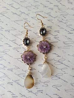 These earrings are so captivating! Super unique and victorian style- oval crystals, purple flower and dangling teardrop shells. The earrings are created with goldtone plated precious metals and hypoallergenic ear hooks. The earrings are so divine, be prepared for an overload of endless compliments. The earrings compliment any style of fashion and a stand out accessory for any special occasion. They're lightweight and ready to be shipped.  Length: 3.5 inches Width: .75 inches  Purchases will be s Elegant Purple Teardrop Flower Earrings, Vintage Purple Teardrop Earrings, Vintage Purple Drop Earrings, Vintage Purple Flower Earrings, Elegant Handmade Purple Clip-on Earrings, Crystals Purple, Jewelry Fancy, Drop Earrings Gold, Purple Jewelry