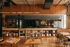 an empty restaurant with wooden tables and chairs