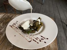 a white plate topped with food on top of a wooden table next to a milk jug