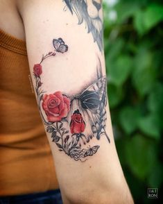 a woman's arm with roses and butterflies on it