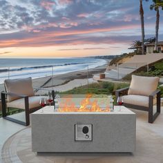 a fire pit sitting on top of a patio next to the ocean