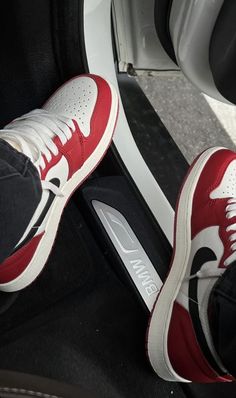 a pair of red and white shoes sitting on top of a car door sill