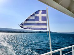 the greek flag is flying from the back of a boat