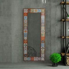 a mirror sitting on top of a wooden shelf next to a potted plant