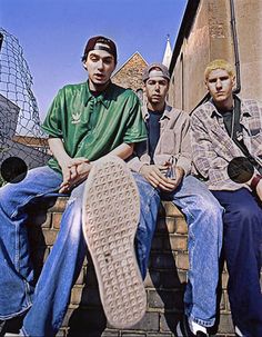 three young men sitting on the steps with their feet up