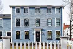 a blue two story house with white picket fence