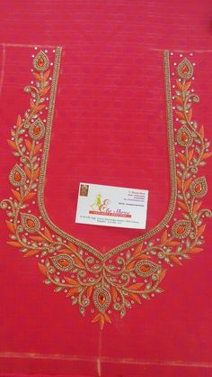 a red cloth with gold embroidery on it and a business card attached to the front