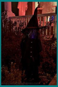 a person in a costume standing on a porch at night with the lights turned on