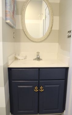 a bathroom with a sink, mirror and striped wallpaper on the walls in it