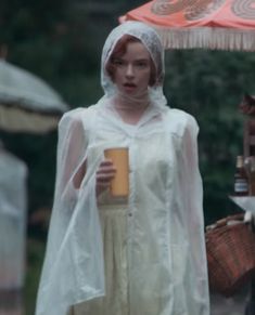 a woman dressed in white holding a cup