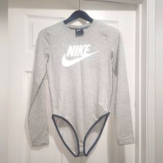 a gray nike bodysuit hanging on a door